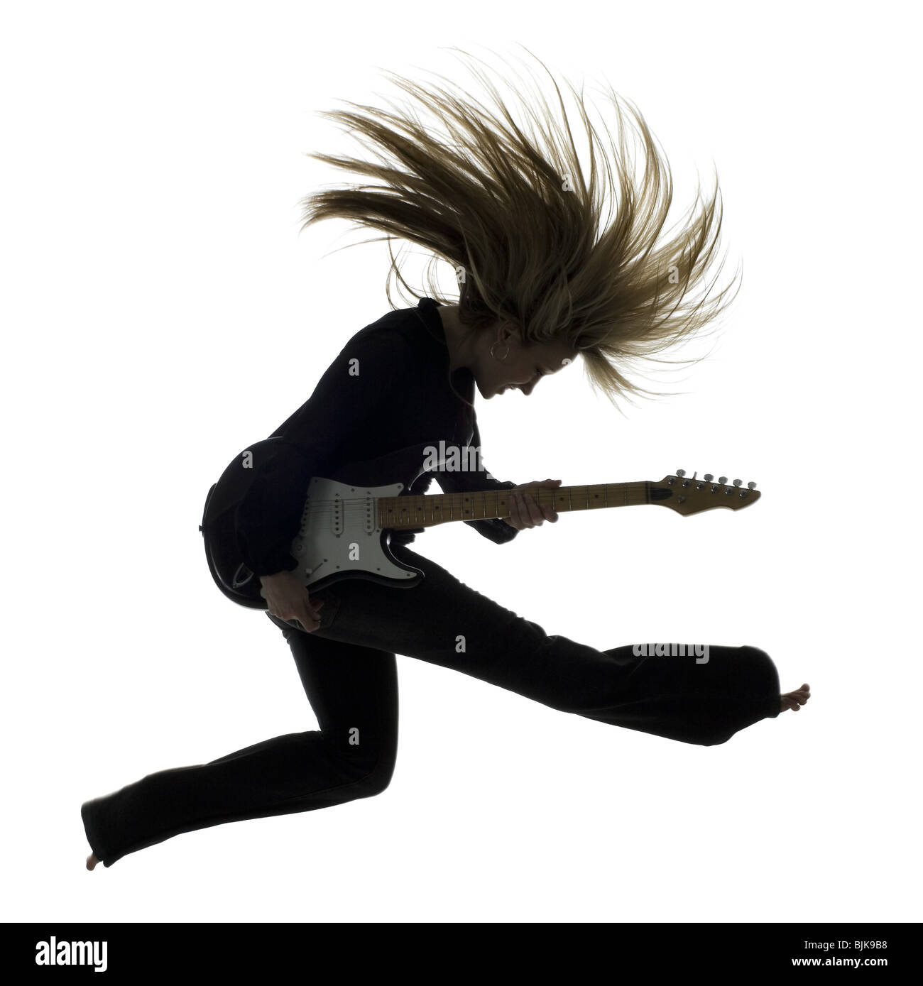 El perfil lateral silueta de mujer saltando con guitarra eléctrica Foto de stock