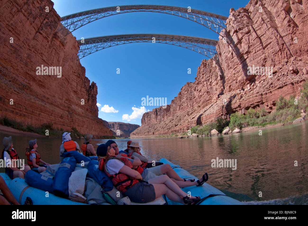 River rafters disfrutar de una balsa por el Río Colorado a medida que pasan bajo el puente Navajo, Grand Canyon National Park Foto de stock