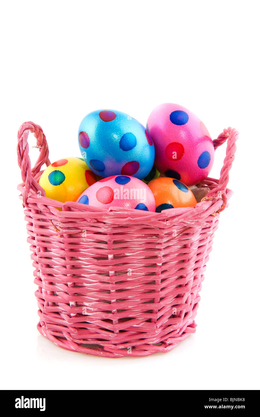 Rosa cesta llena de colorido manchada de huevos de Pascua Foto de stock