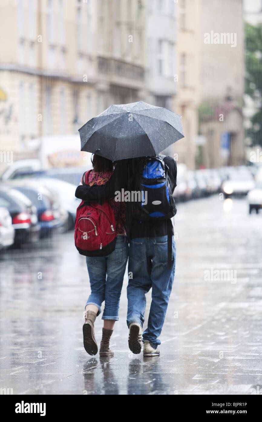 Pareja con paraguas en la lluvia Fotografía de stock - Alamy