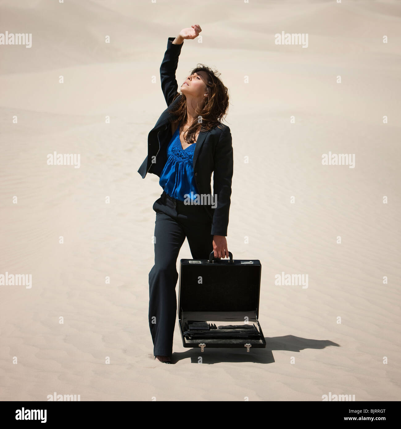 Estados Unidos, Utah, pequeño Sáhara, joven empresaria en Desert Sun protección permanente con brazo Foto de stock