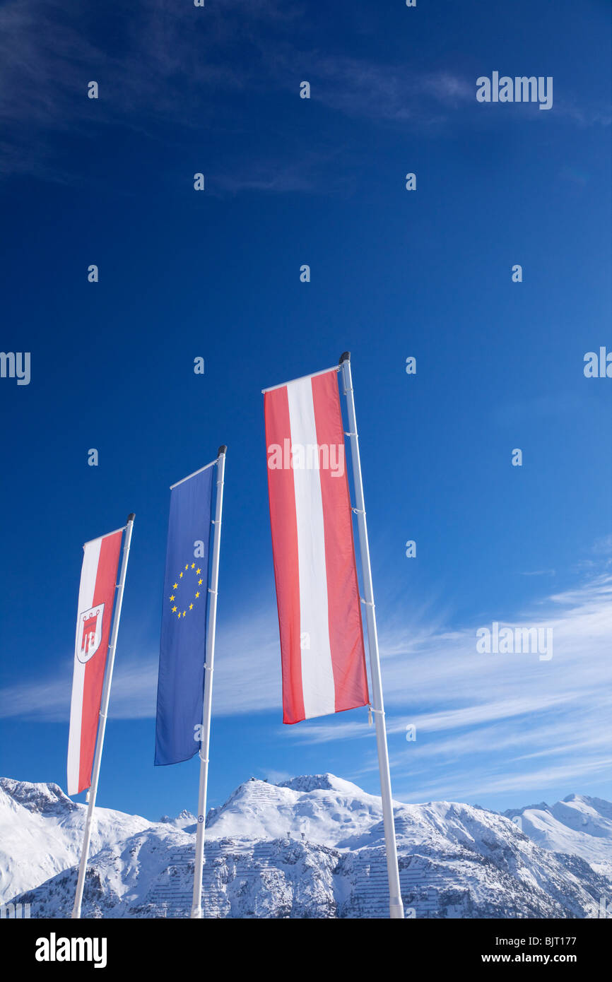 Las banderas de la Unión Europea austriaca y montañas Lech cerca de St San Anton am Arlberg en invierno la nieve de los Alpes austriacos Austria Europa Foto de stock