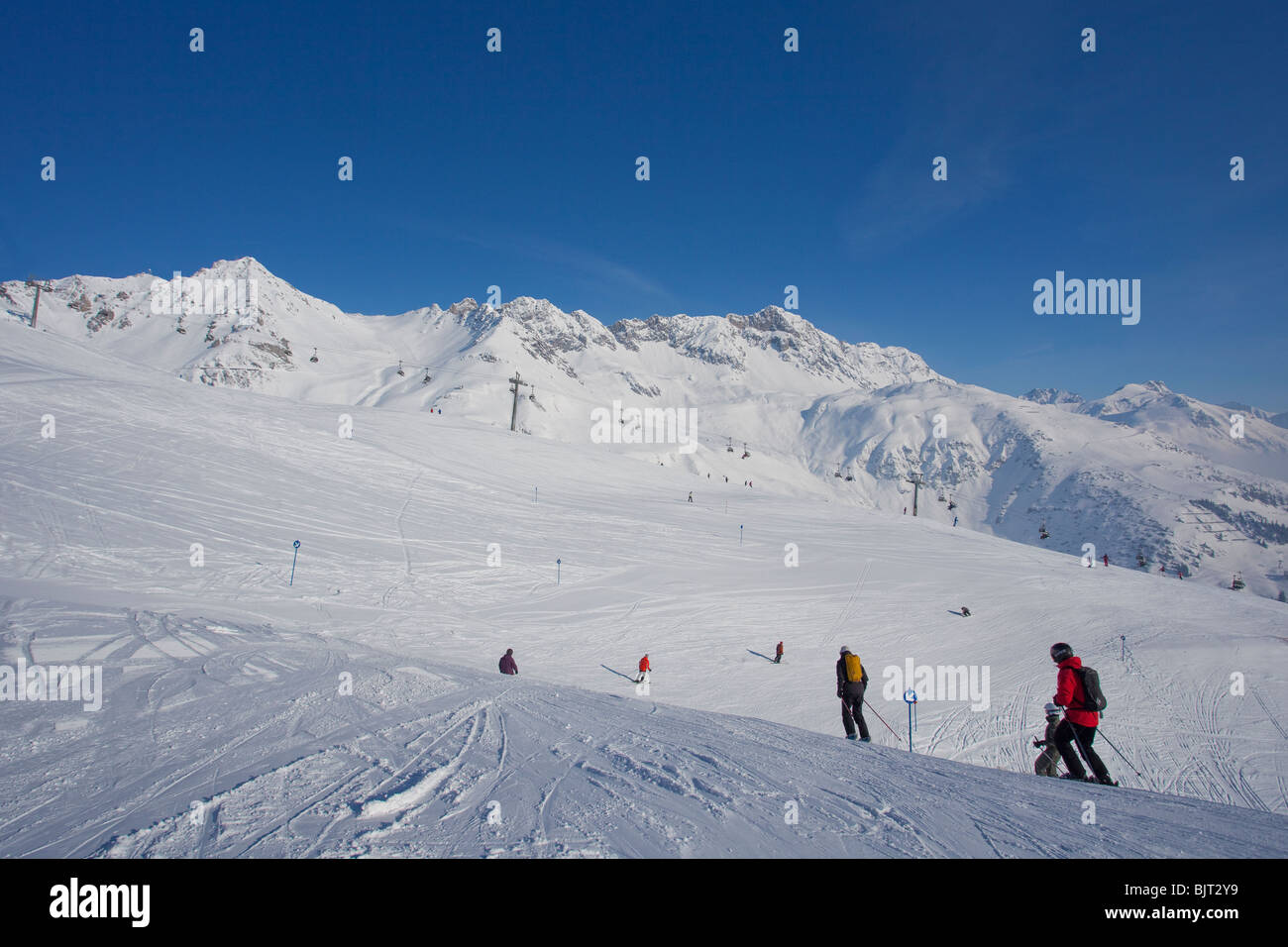 Los esquiadores descender esquiando desde las pistas de esquí de montaña Galzig nieve del invierno San San San Anton am Arlberg Alpes Austriacos Austria Europa montañas Foto de stock