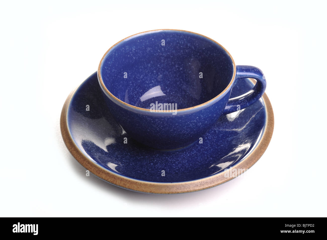 Taza y plato de té azul fotografiado en estudio con un fondo blanco. Foto de stock