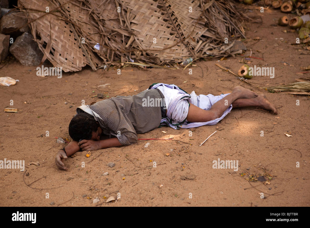 India, Kerala, Palakkad, intoxicado hombre dormido en polvo al costado de la carretera Foto de stock
