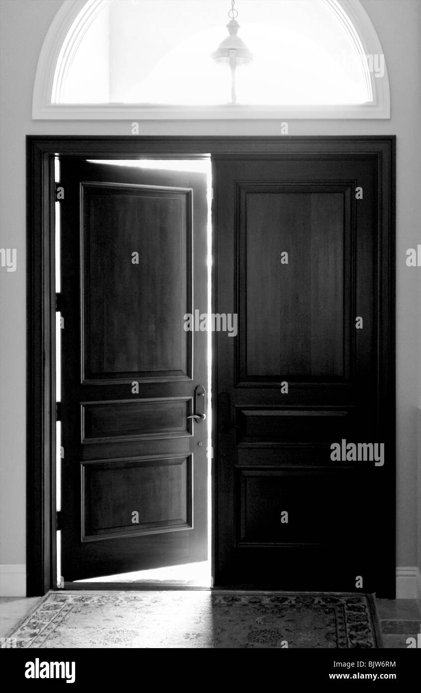 Imagen en blanco y negro de grandes puertas de entrada de madera oscura con  arcos de ventana superior Fotografía de stock - Alamy