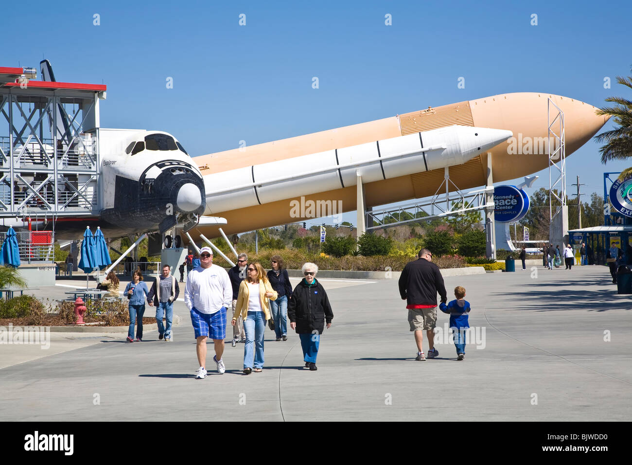 La gente caminando delante de la Lanzadera y booster exposiciones en el Complejo para Visitantes del Centro Espacial Kennedy en Florida Foto de stock
