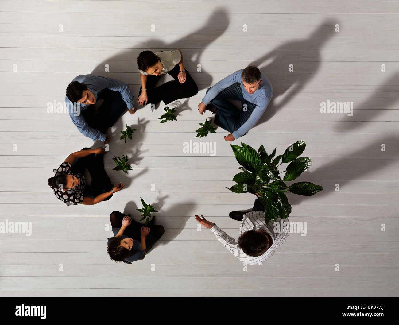 Grupo de personas en el piso con plantas Foto de stock