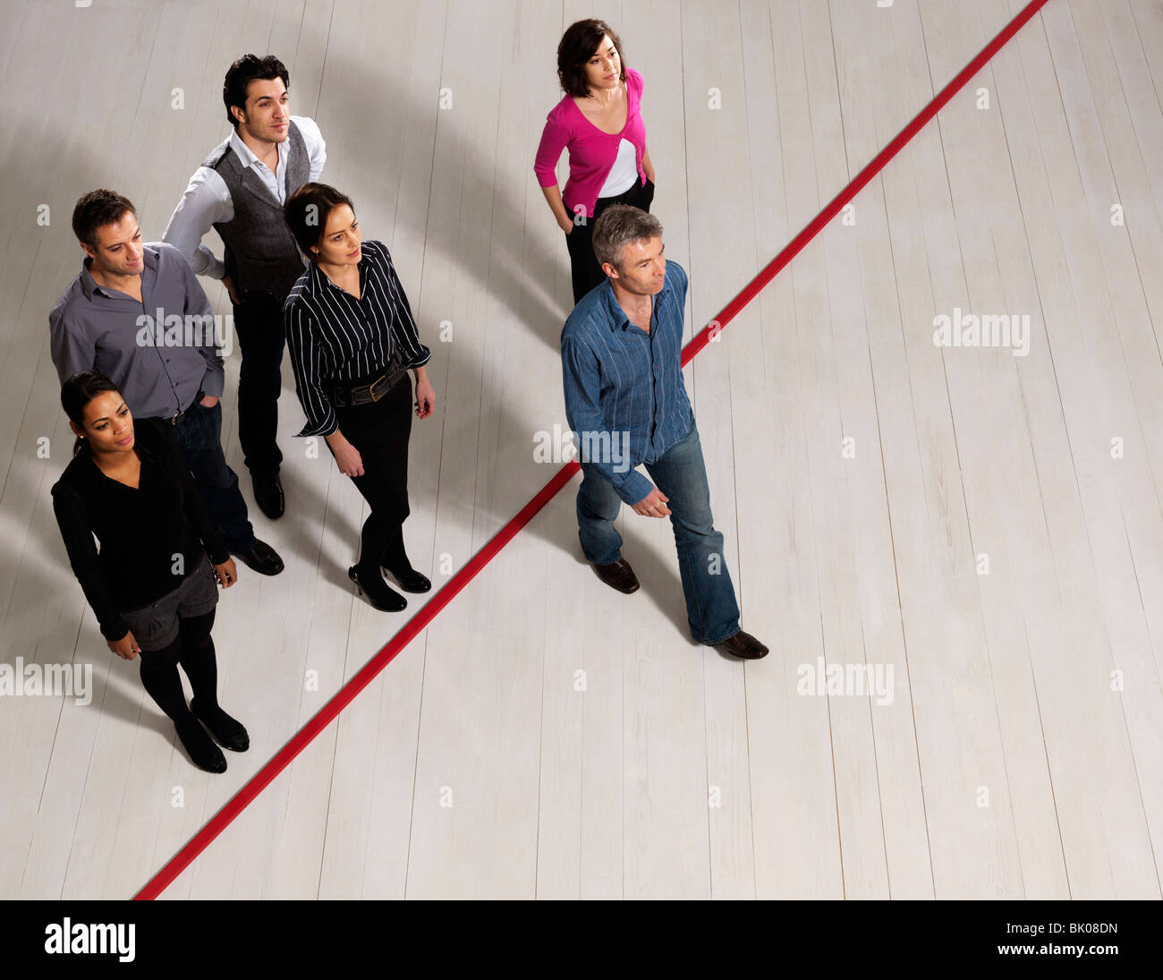 Los hombres y mujeres de negocios cruzando la línea roja Foto de stock