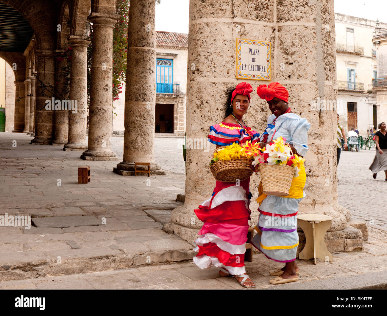 La mujer en coloridos trajes tradicionales con canasta de flores en la Habana Vieja Foto de stock