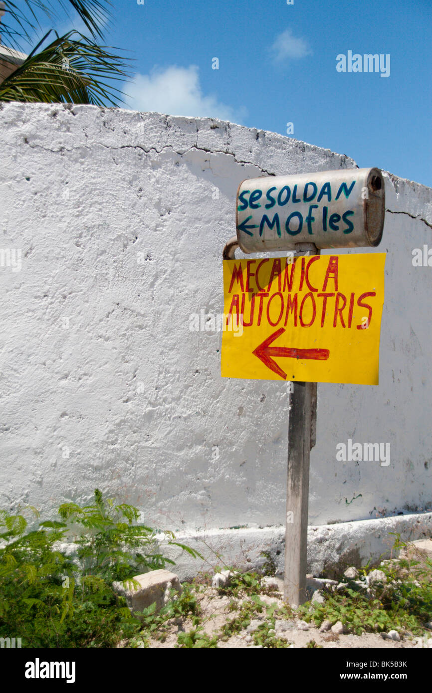 Un cartel de publicidad de un taller de reparaciones mecánicas y el silenciador en la isla de Isla Mujeres, cerca de Cancún, México Foto de stock