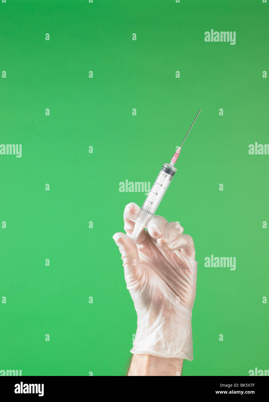 Medical mano enguantada con jeringas y agujas Foto de stock
