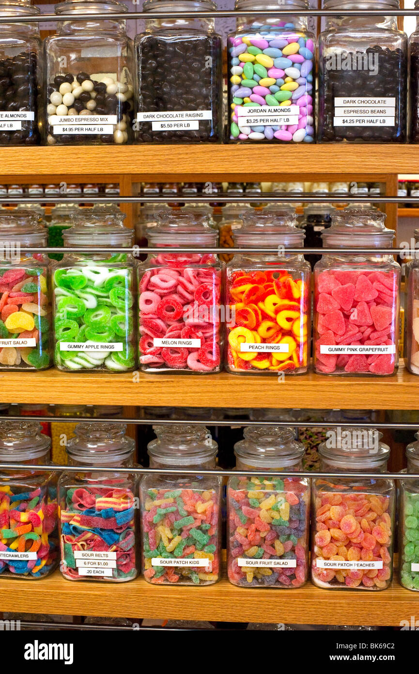 Tarros de golosinas en los estantes de una tienda de caramelos Foto de stock