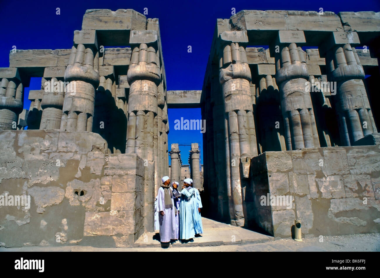 Louxor, Egipto, Vista General de Louxor templo egipcio con un grupo de hombres hablando cerca de las columnas de Thoutmosis III. Foto de stock