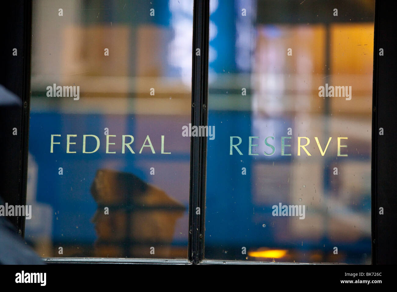 Guardia de seguridad reflexión en la puerta del Banco de la Reserva Federal de Nueva York Foto de stock