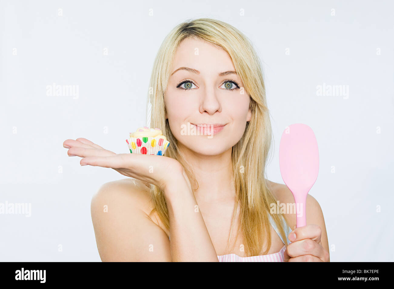 Mujer joven con cupcake y cuchara Foto de stock