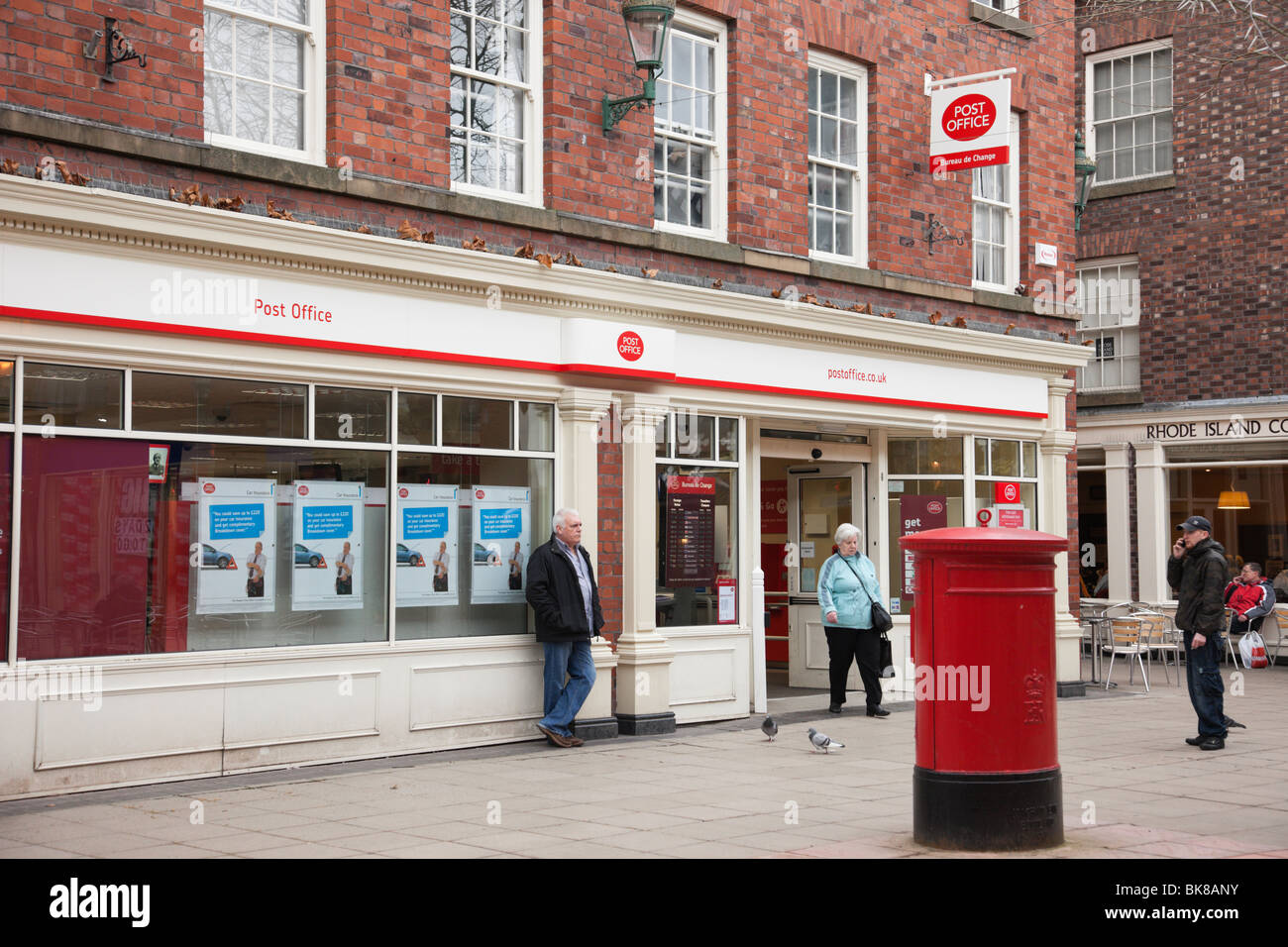 Escena de una calle fuera de una oficina de correos con postbox con la gente. En Warrington, Cheshire, Inglaterra, Reino Unido. Foto de stock