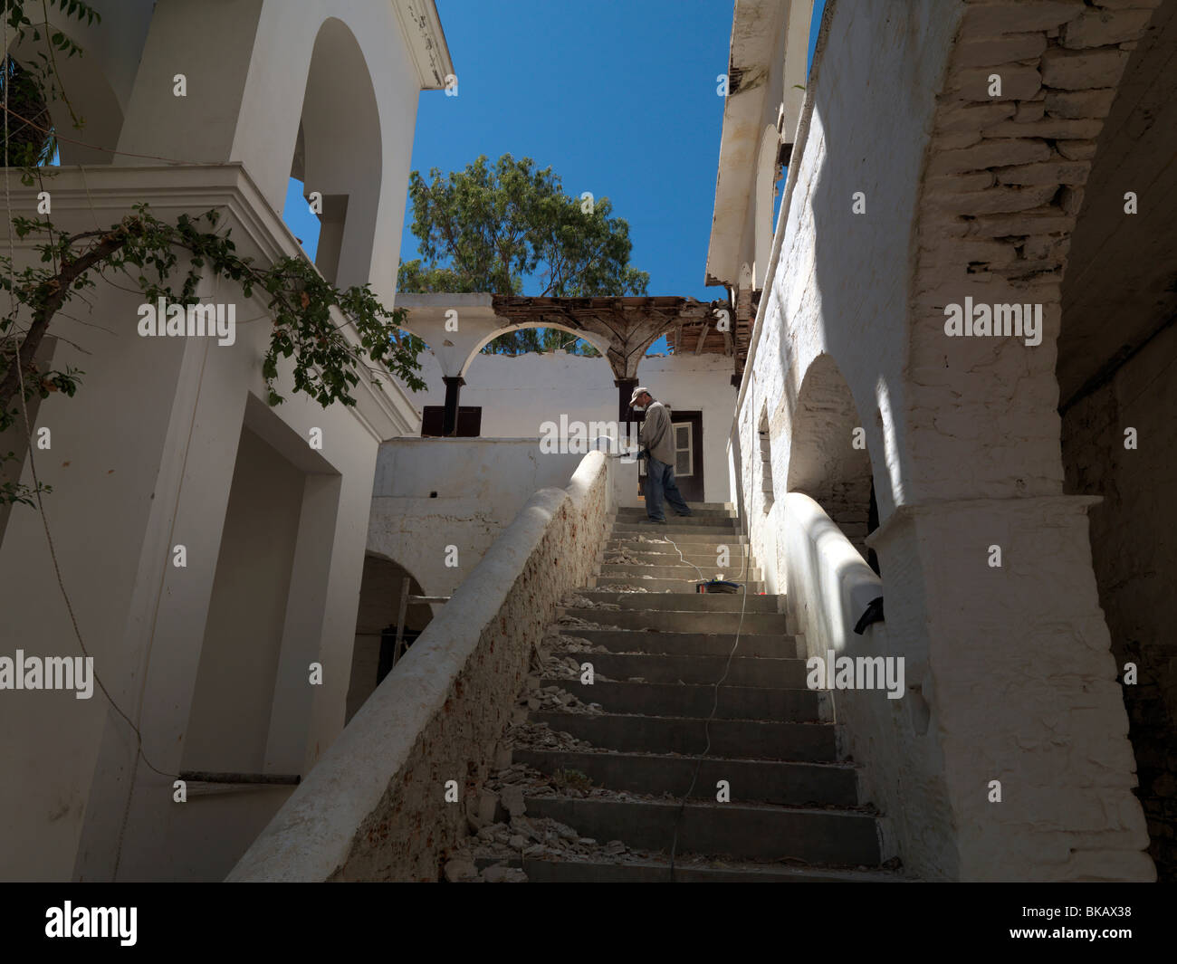 Monasterio de Samos Grecia Agia Zoni hombre trabajos de restauración financiados por la UE en escaleras Perforación Foto de stock