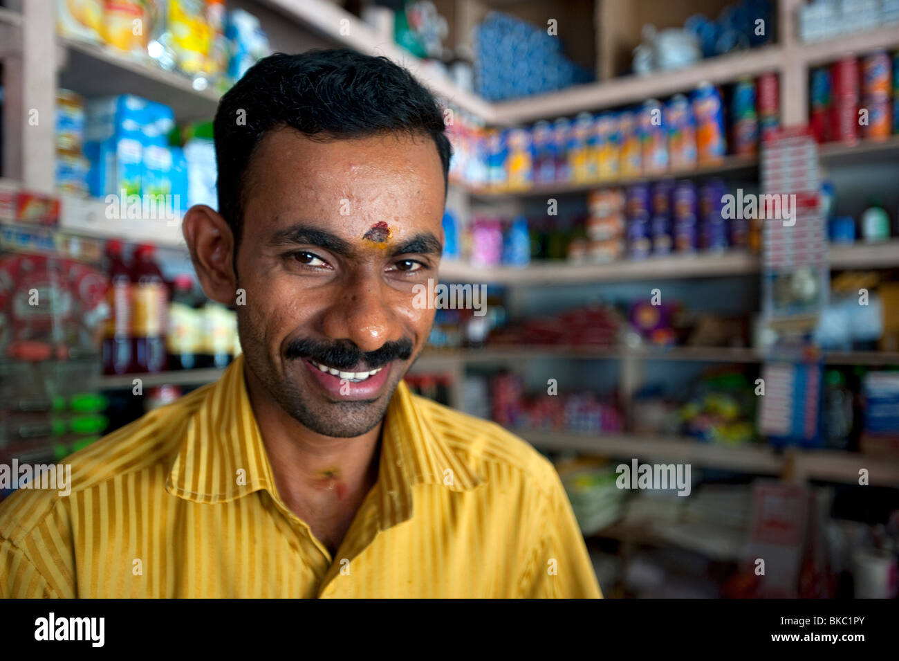 Hombre local en la tienda de ultramarinos, Kovalam, Kerala, India Foto de stock