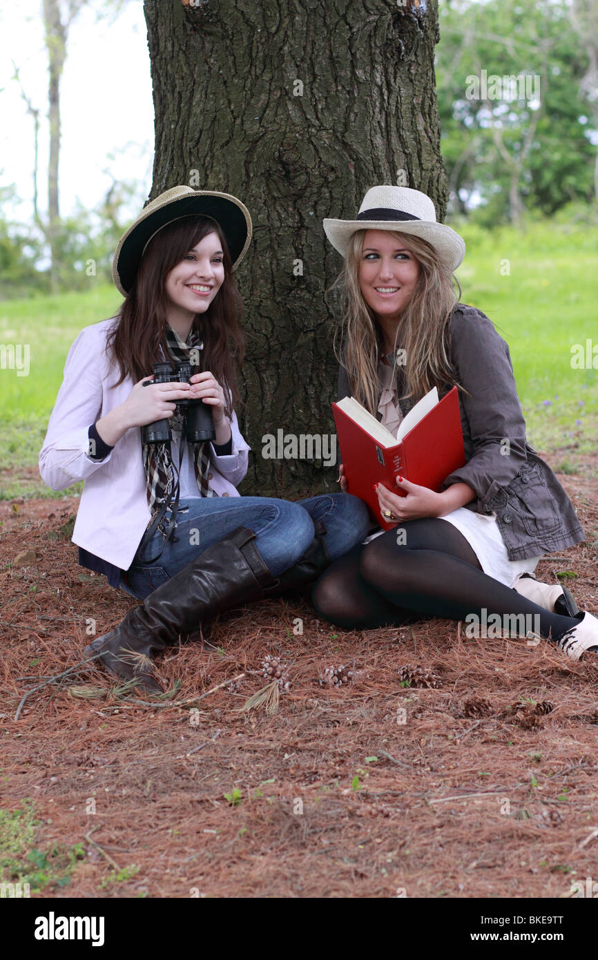 Dos adolescentes de moda avistaje de aves con guía y binoculares Foto de stock