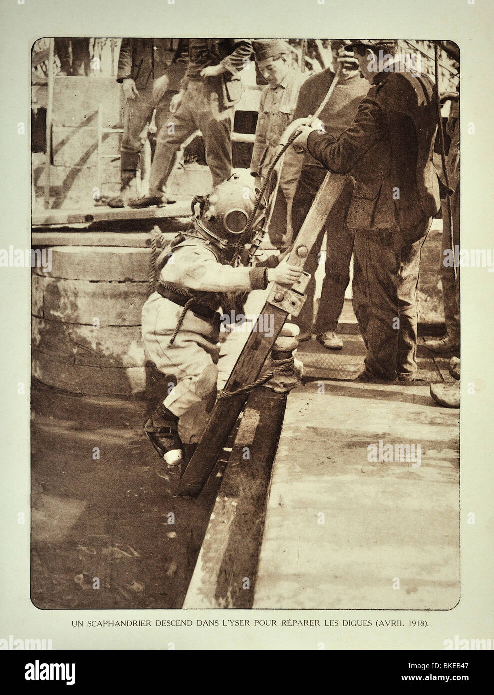 WWI con casco de buzo desciende la escalera para reparar el dique a lo largo de río Yser / IJzer en Flandes durante la Primera Guerra Mundial, Bélgica Foto de stock