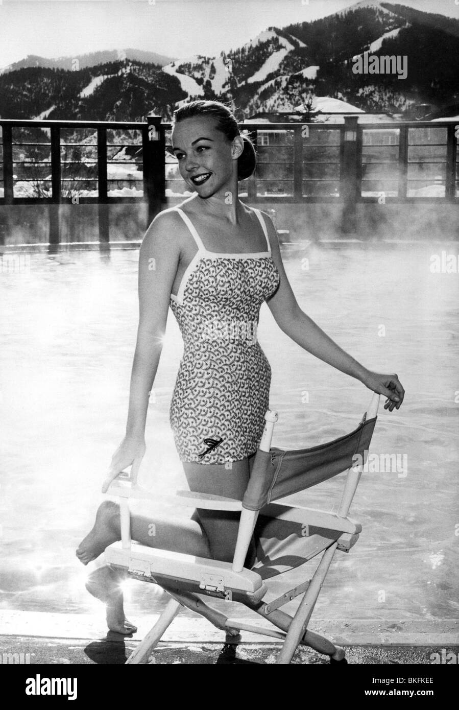 Moda, 50 años, moda femenina, ropa de playa, mujer que lleva traje de baño, arrodillándose en la silla director, Sun Idaho, 1956 Fotografía de - Alamy