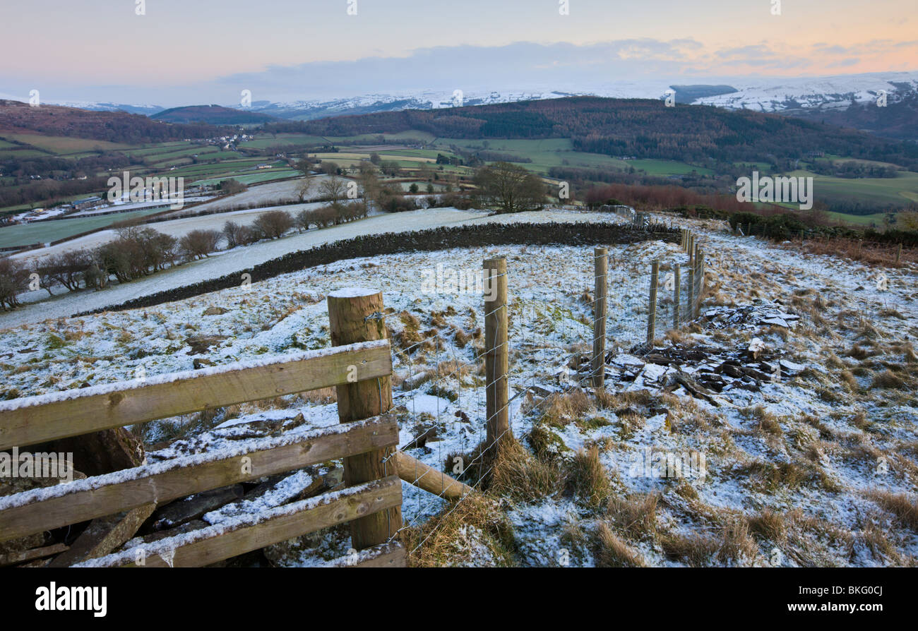 Desempolvar el cerco y campos de nieve mirando hacia Bwlch y montañas nevadas más allá, el Parque Nacional de Brecon Beacons, Powys, Gales, Reino Unido Foto de stock