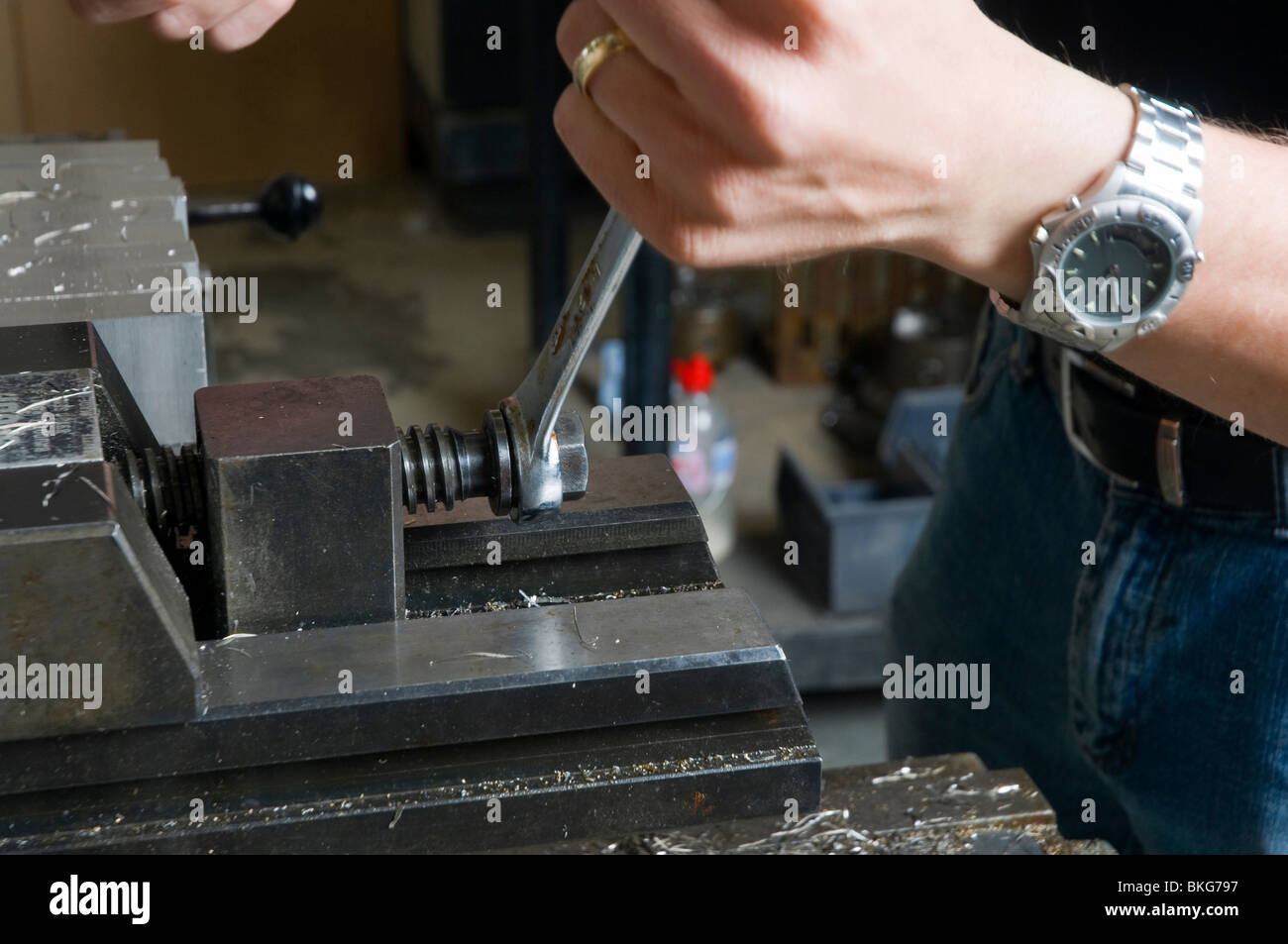 Sujeción de una pieza en el lugar en una fresadora utilizando una máquina de vicio, apretar con una llave inglesa, ingeniería de precisión. Foto de stock