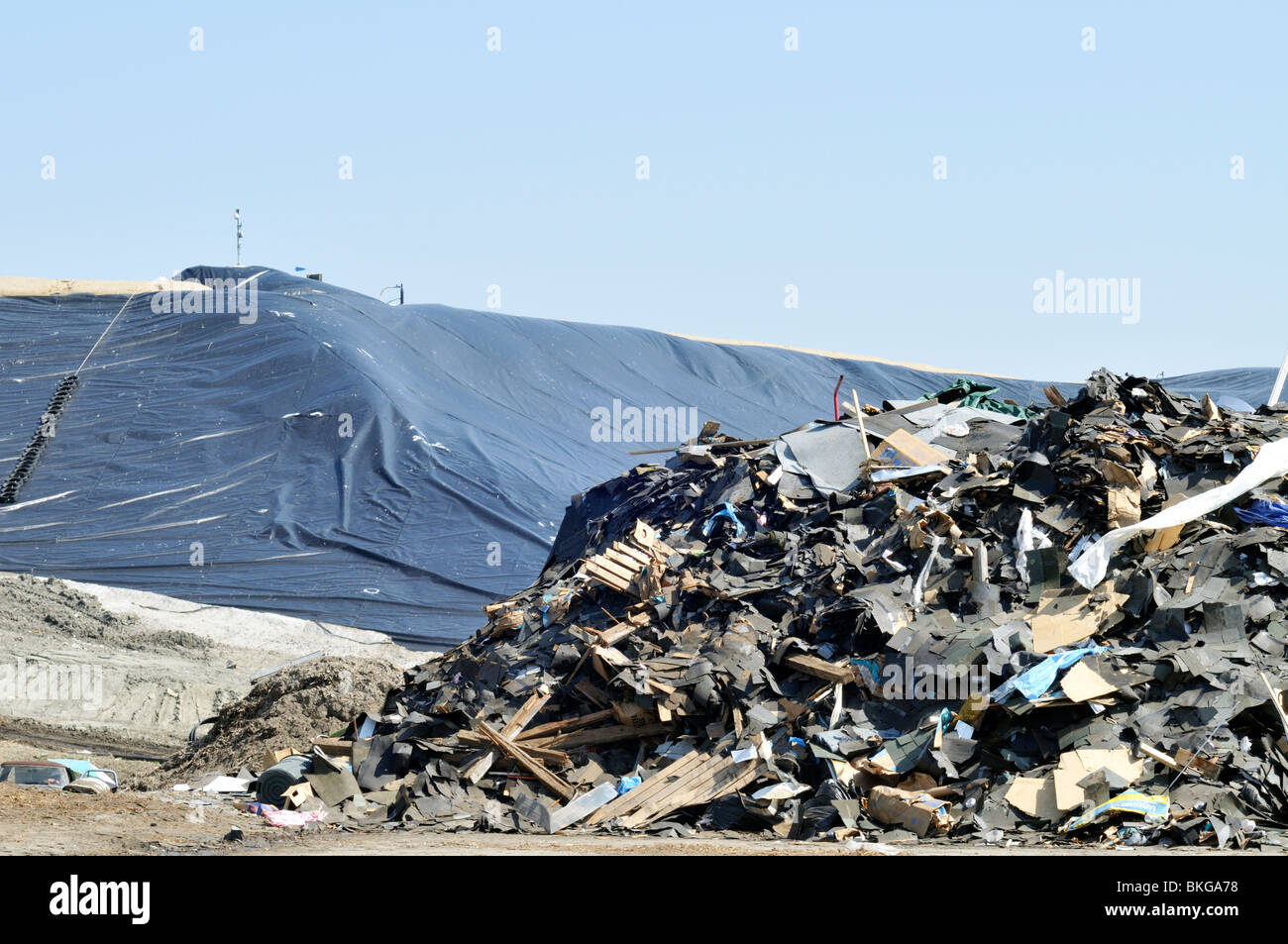 Volcado de vertederos con pila de basura y escombros de construcción comercial con encapsulado plástico US Foto de stock