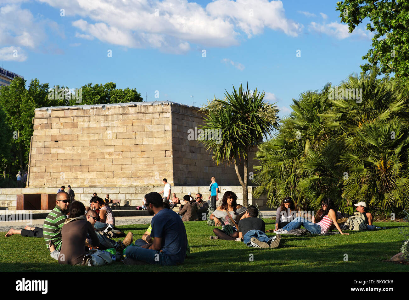 Jóvenes sentados en la hierba cerca del Templo de Debod, Madrid, España Foto de stock