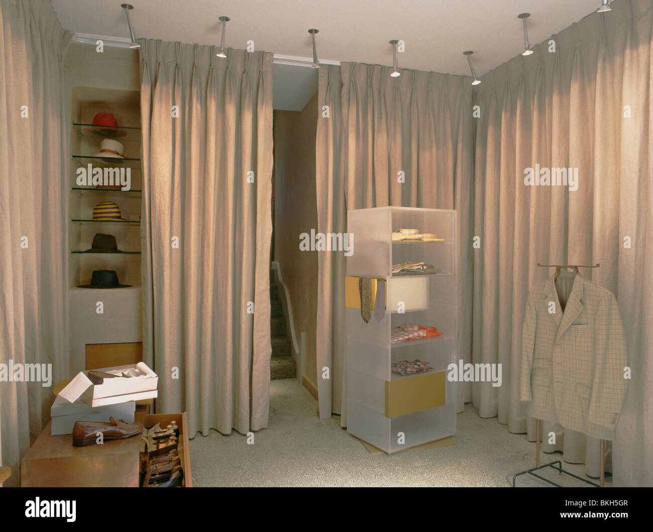 Destaca por encima de perspex estanterías en vestidor con cortinas beige  ocultando el almacenamiento Fotografía de stock - Alamy