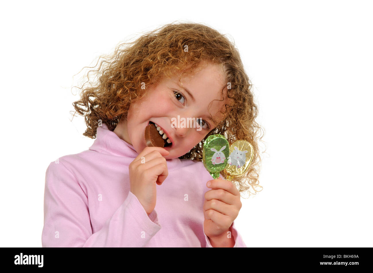Niña de seis años con un diente frontal suelto comiendo una barra de