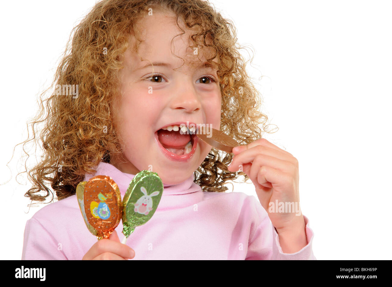 Niña de seis años con un diente frontal suelto comiendo una barra de