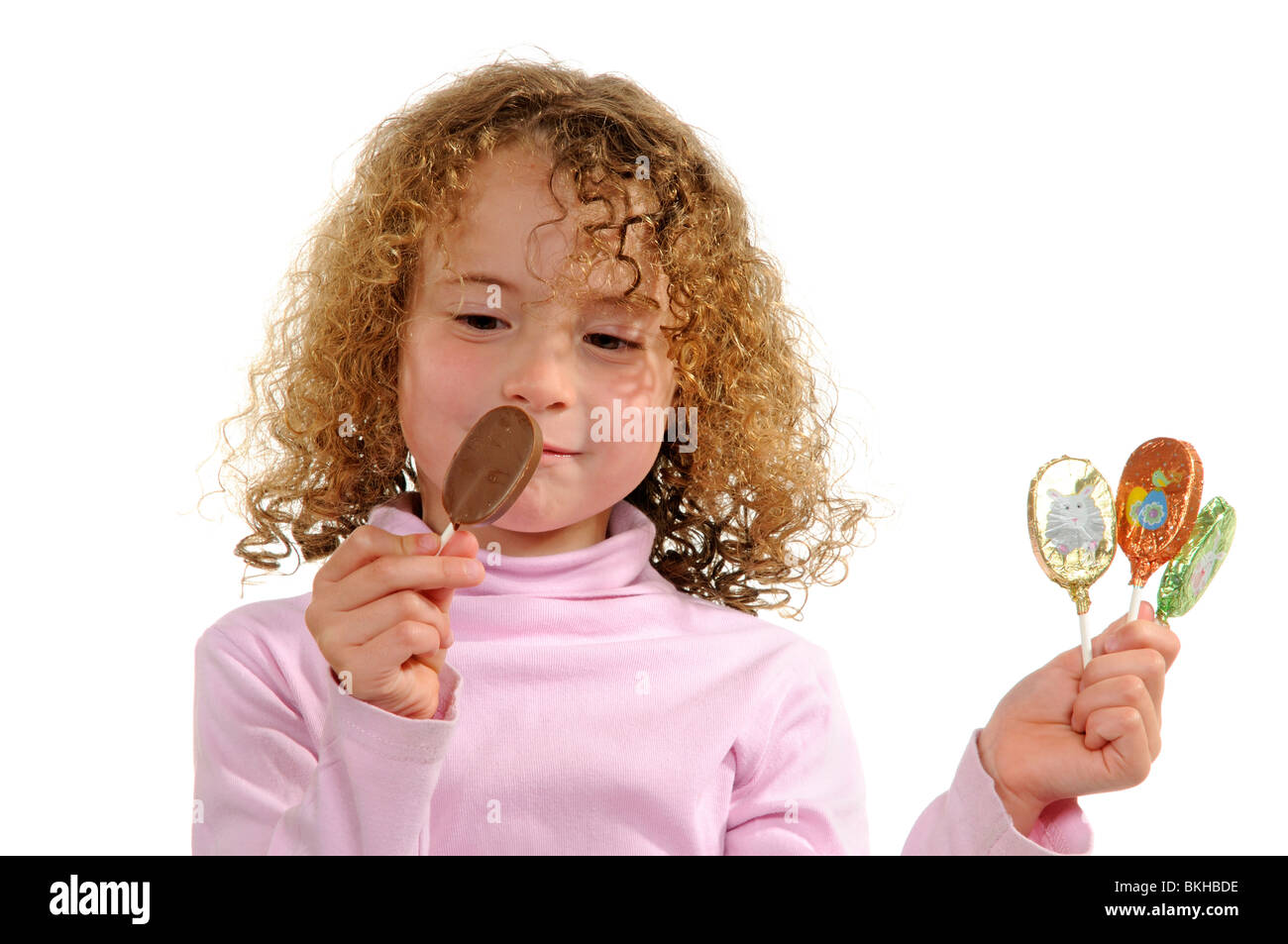 Niña de seis años con un diente frontal suelto comiendo una barra de