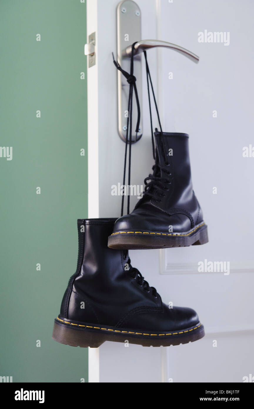 Un par de botas negras atadas por los cordones y colgando de un pomo  Fotografía de stock - Alamy