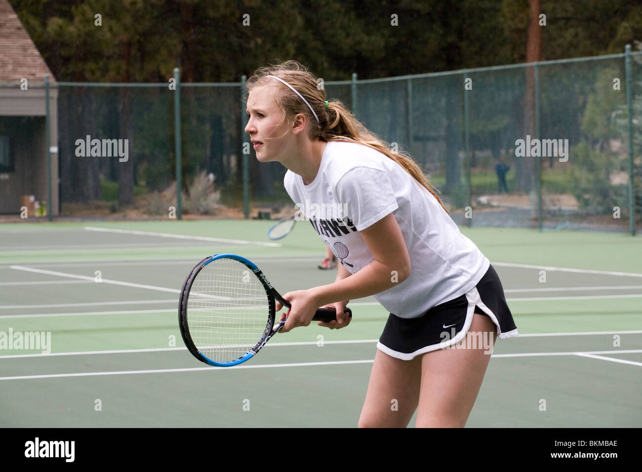 Un jugador de tenis high school en el varsity team en un partido de tenis Foto de stock