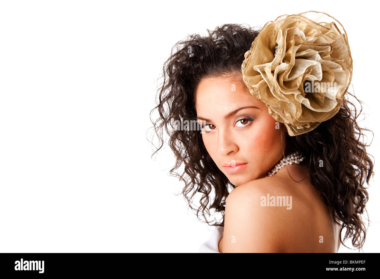 Hermoso rostro de una mujer hispana con caucásicos curtida piel clara, vistiendo un collar de perlas y una falsa flor en el pelo rizado. Foto de stock