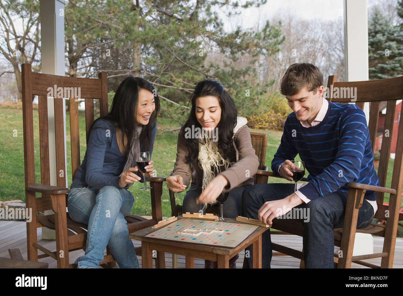 Amigos jugando Scrabble en porche Foto de stock