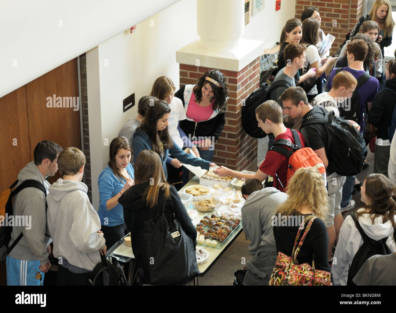 Los estudiantes de secundaria reunidos en la escuela después de una venta de pasteles para recaudar fondos. Foto de stock