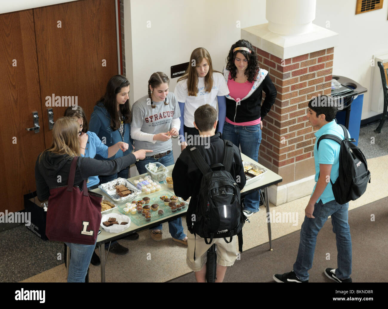 Los estudiantes de secundaria reunidos en la escuela después de una venta de pasteles para recaudar fondos. Foto de stock