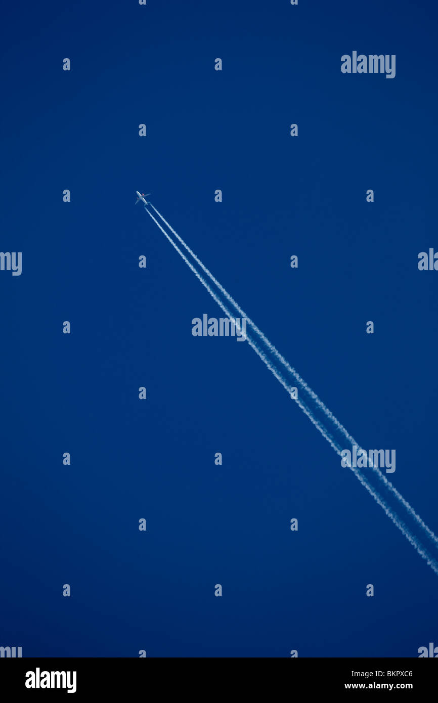 Un avión de pasajeros de EasyJet deja un rastro de vapor a través de un azul cielo despejado en Gran Bretaña Foto de stock