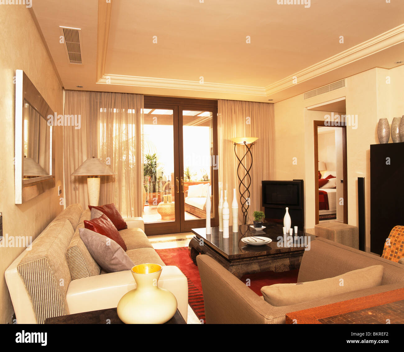 Sofás de color crema en español moderno salón con cortinas de lino