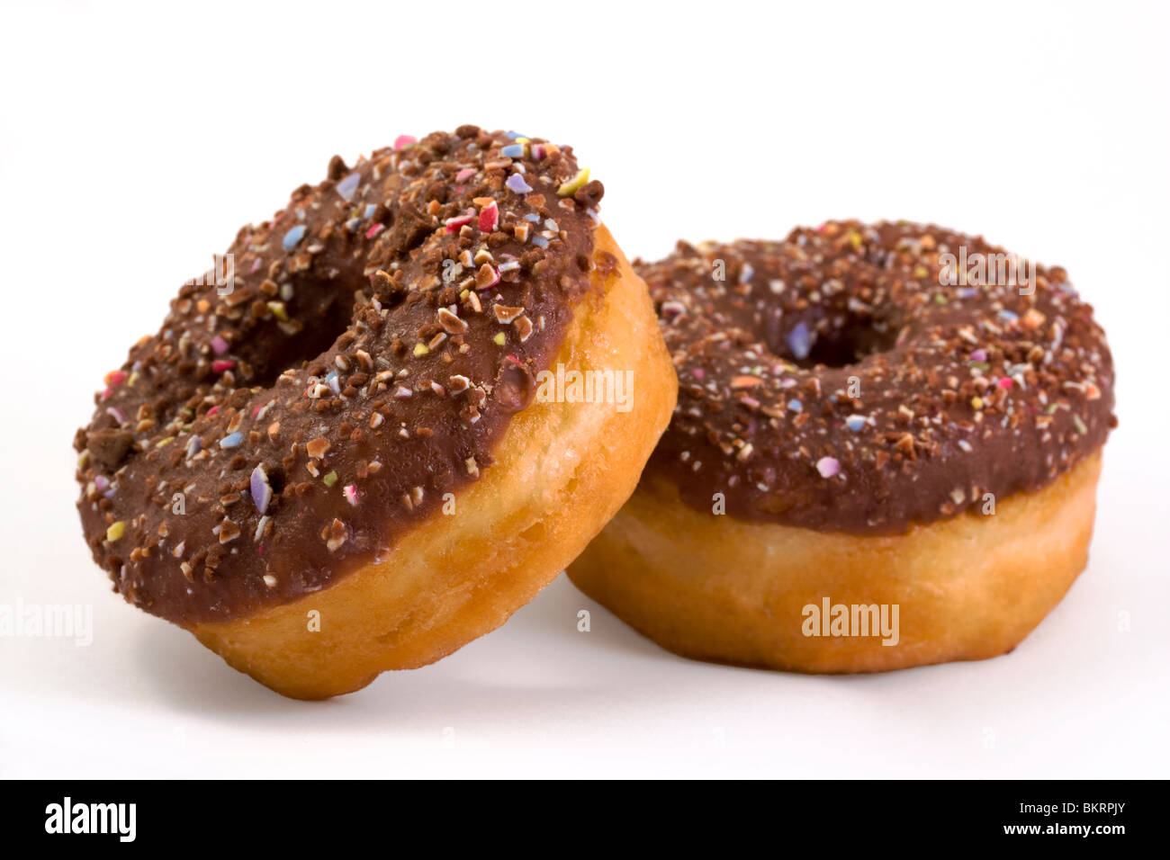 Dos cubiertas de chocolate donuts sobre blanco Foto de stock