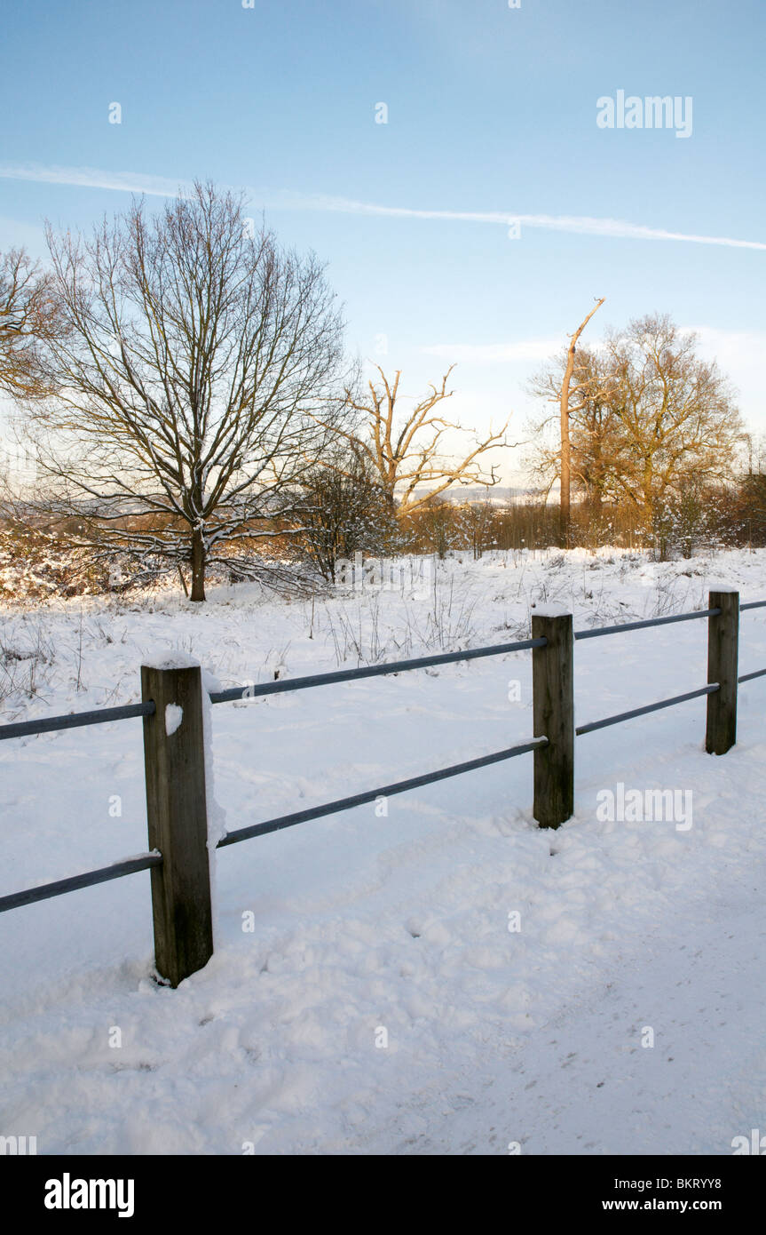 Un sendero cubierto de nieve con una valla Foto de stock