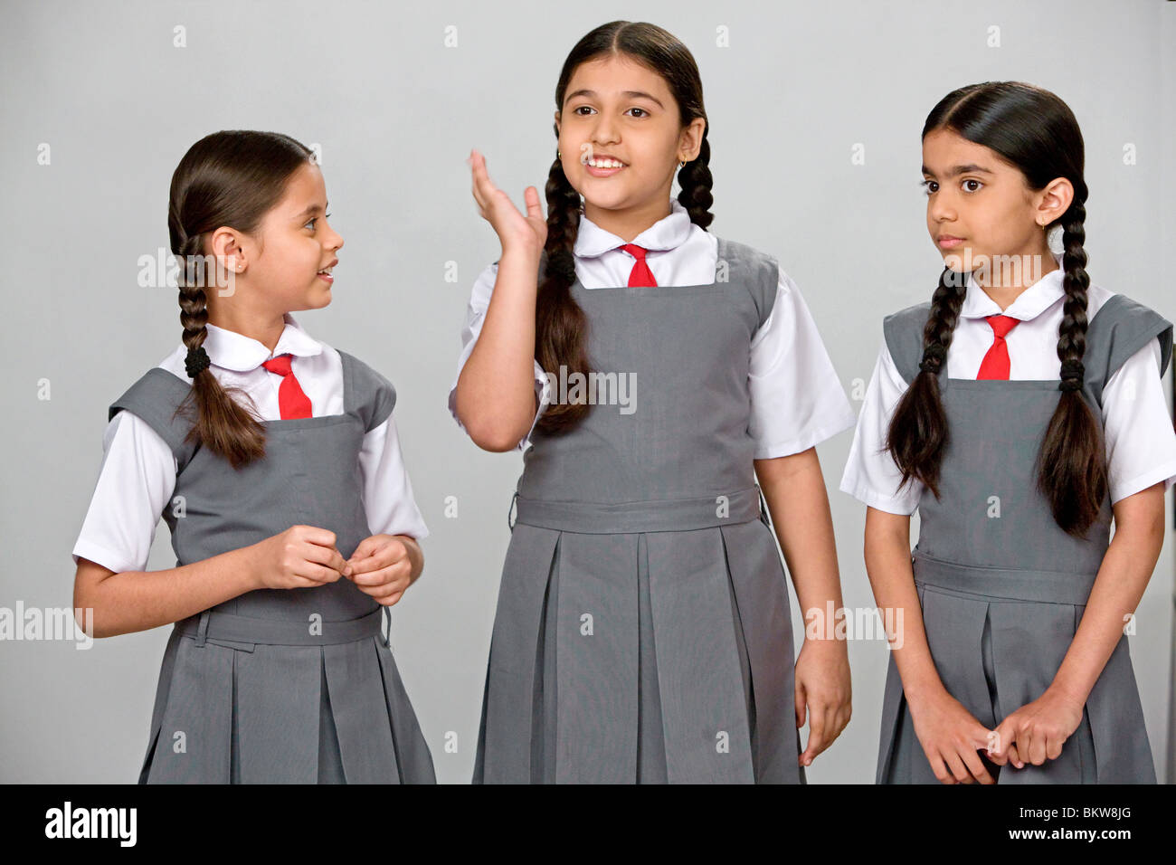 Tres niñas vestían uniforme escolar hablando Fotografía de stock - Alamy