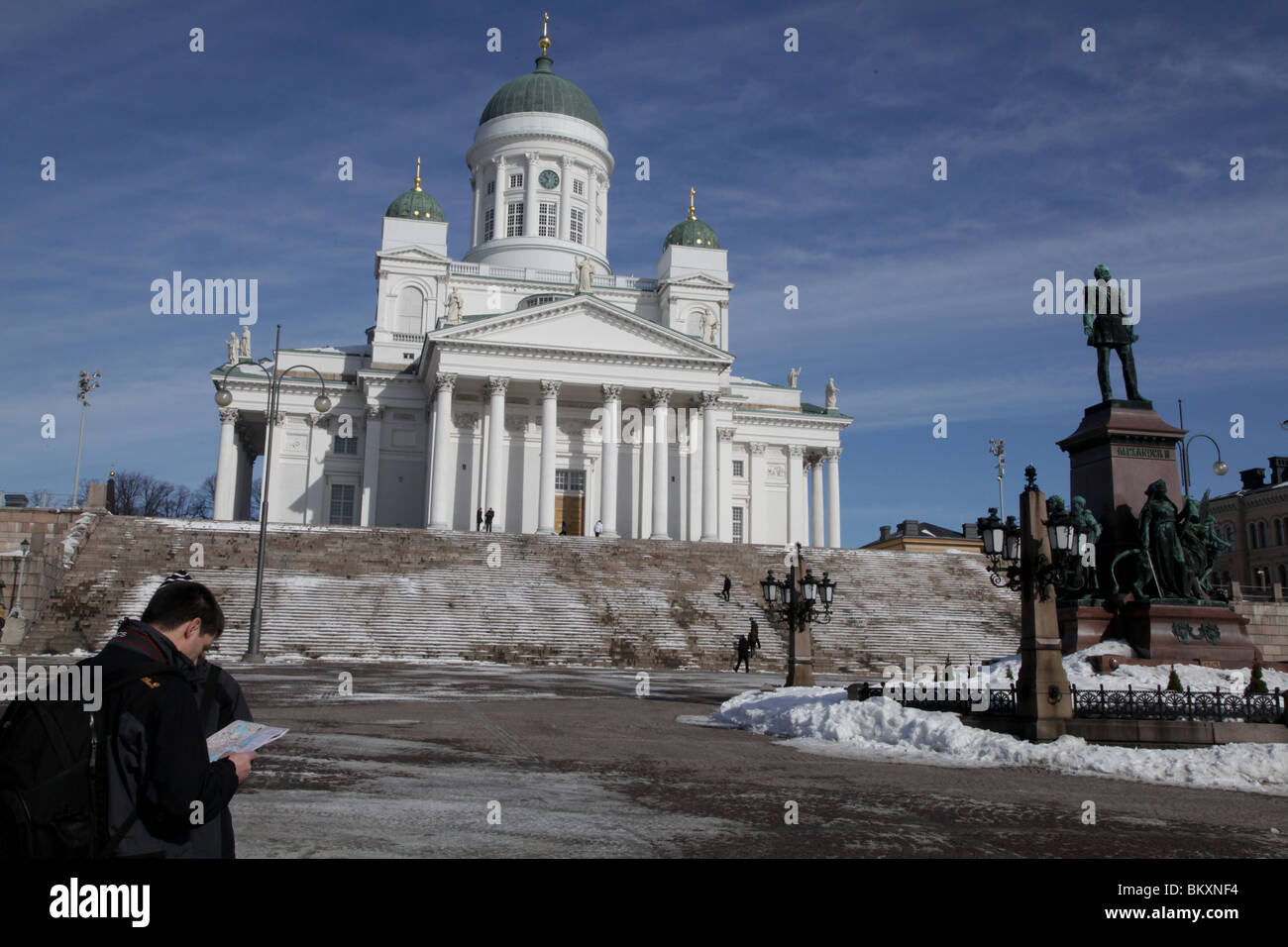 CATEDRAL, TURISTAS, MAPA, HELSINKI: Los turistas comprueban leer mapa Helsinki Plaza del Senado Catedral Escalones nieve Invierno, Finlandia Foto de stock