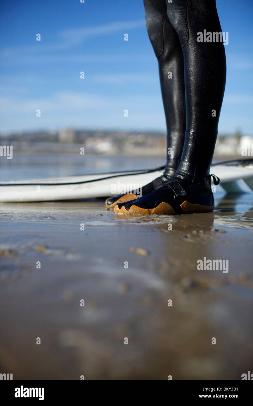 Surfer's pies húmedos en sus botines en la arena mojada por la tabla de  surf en un día soleado en Pacific Beach, San Diego Fotografía de stock -  Alamy