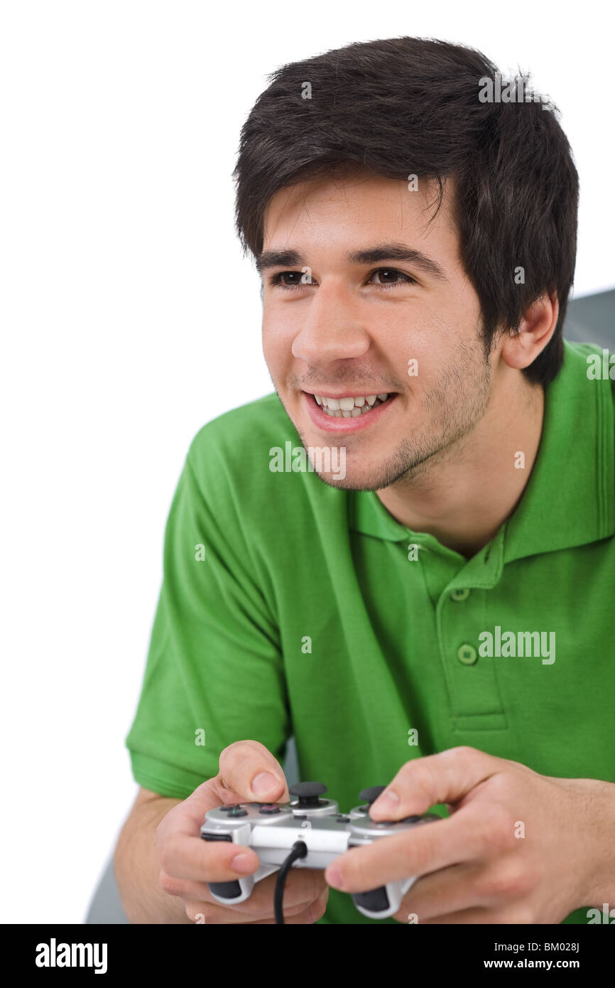 Joven hombre feliz jugando juegos de vídeo con control pad sobre fondo blanco. Foto de stock