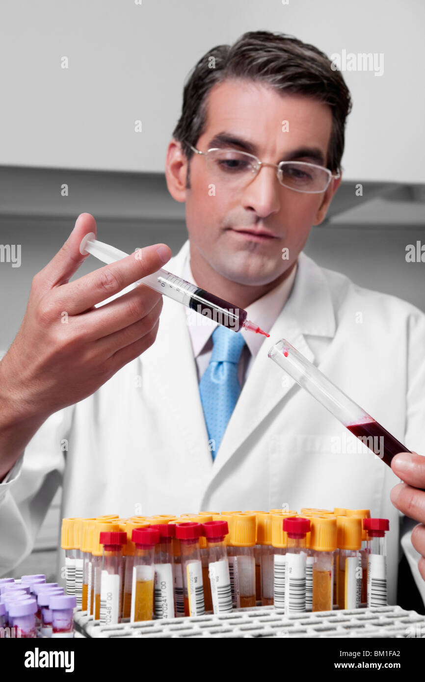 Técnico de laboratorio el llenado de sangre en un tubo de ensayo a partir  de una jeringa Fotografía de stock - Alamy