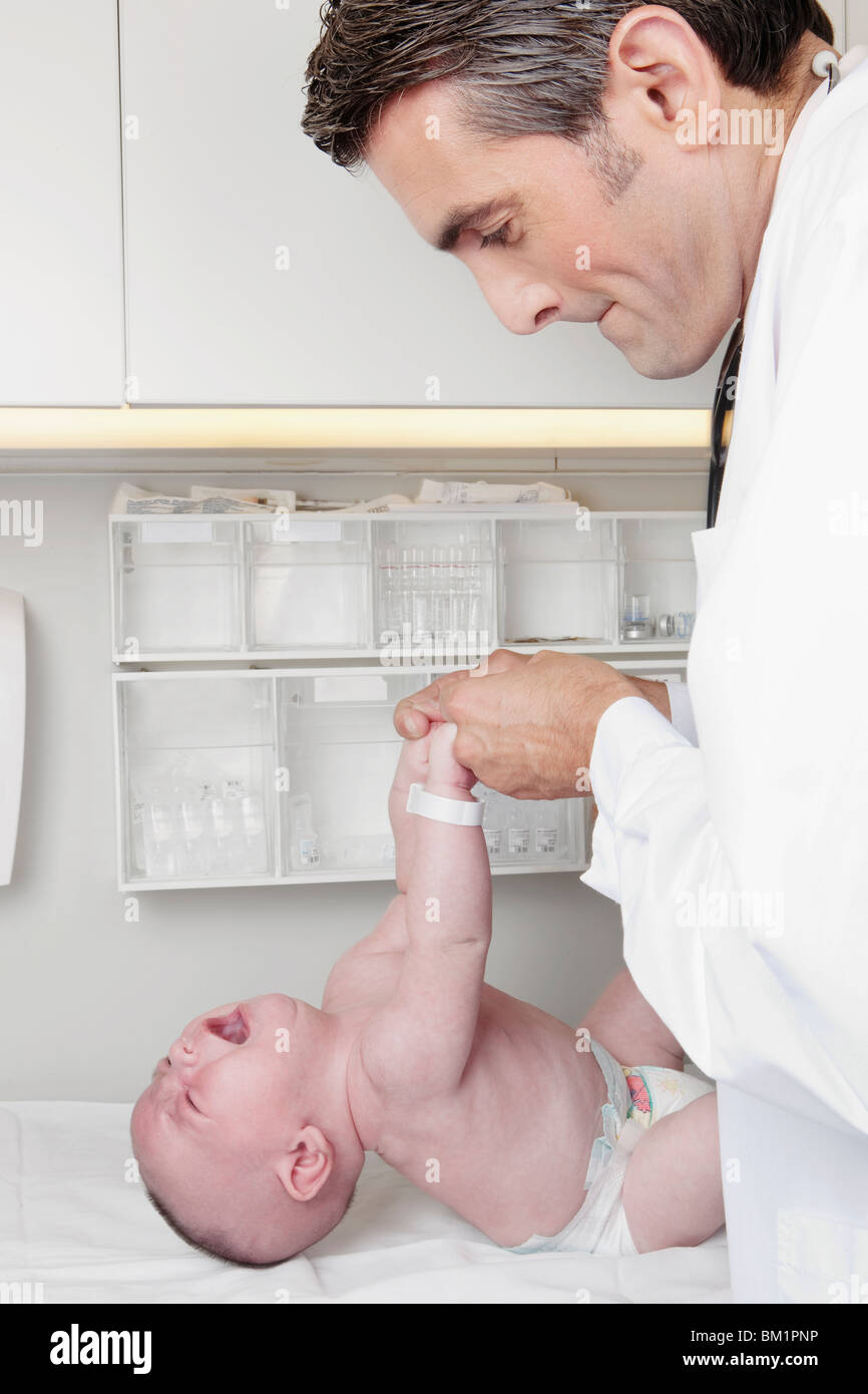 Médico examina un bebé recién nacido Foto de stock